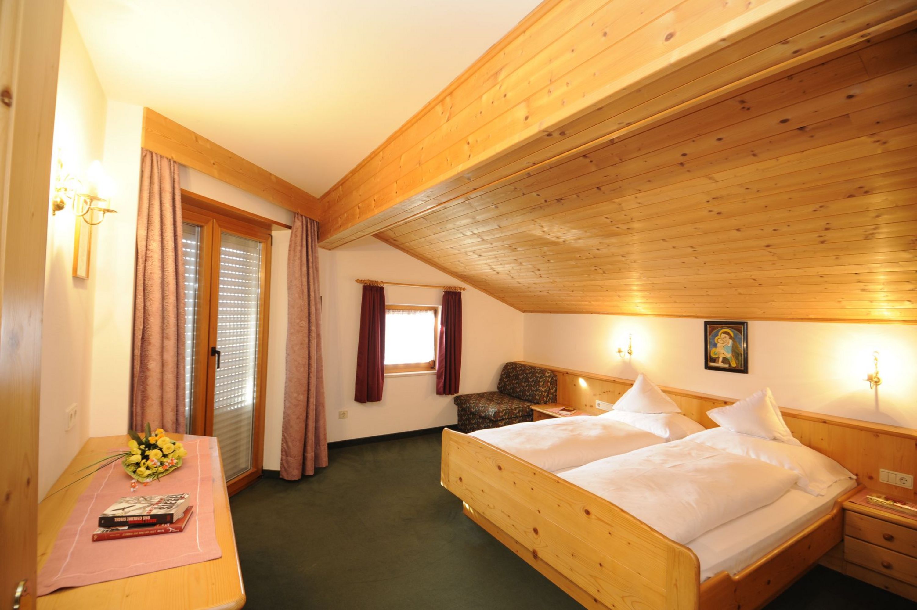 Gemütliches Schlafzimmer mit Holzmöbeln und schräger Decke