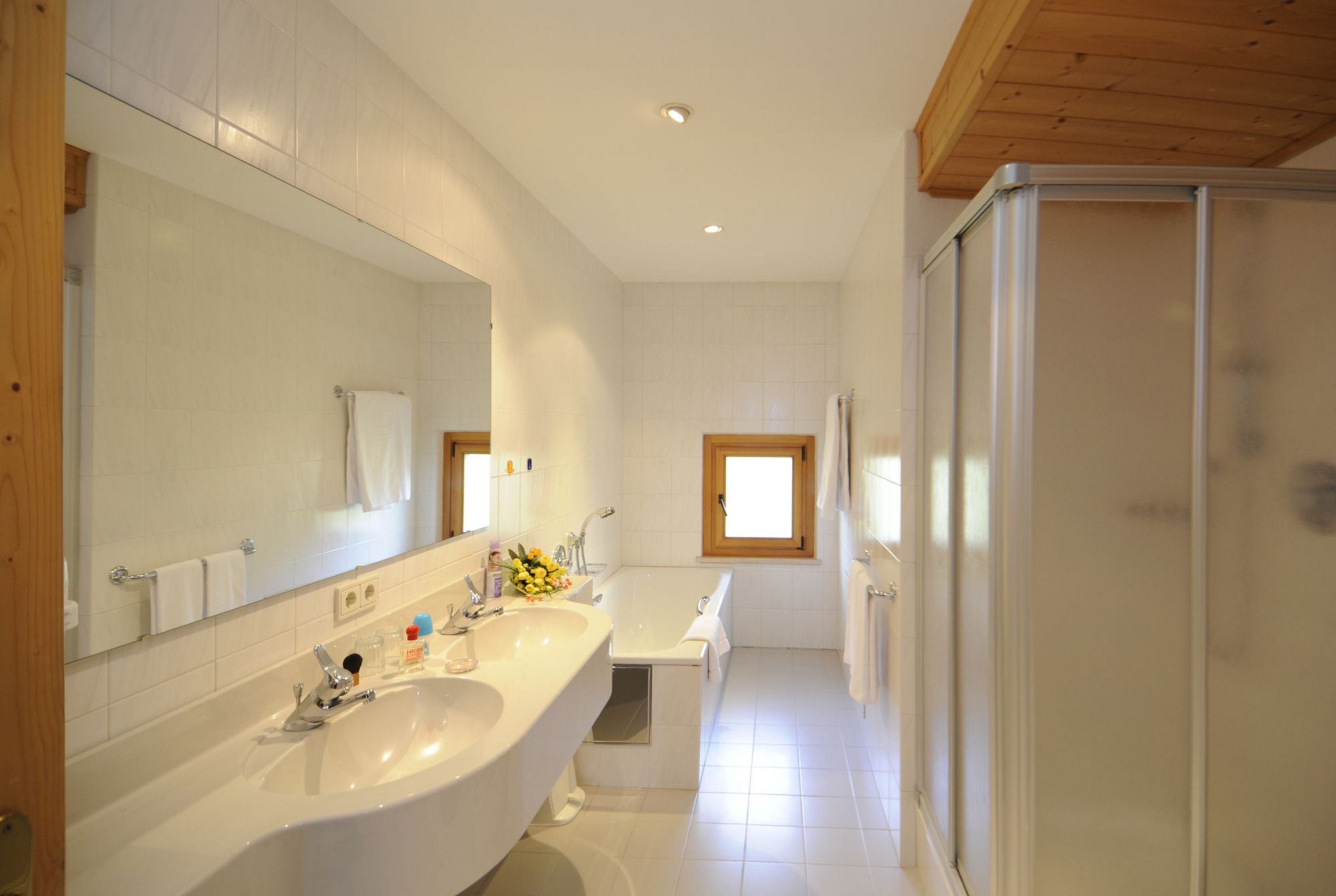 Modernes Badezimmer mit Doppelwaschbecken, Badewanne und Dusche.